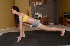 Cute brunette babe Aruna Aghora doing yoga in shorts and bare feet on chickinfo.com