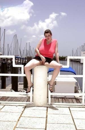 Plump pornstar Desirae flashing her huge tits and upskirt pussy on boat dock on chickinfo.com