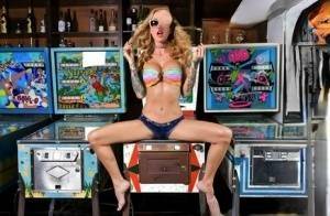 Inked chick Sarah Jessie toys her pussy atop a pinball machine while alone on chickinfo.com