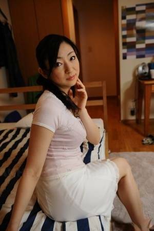 Slender mature Japanese woman Emiko Koike bends over to pose in white dress - Japan on chickinfo.com