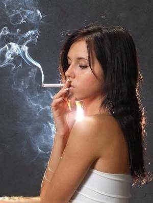 Young brunette smokes a cigarette while wrapped in tight white dress and heels on chickinfo.com