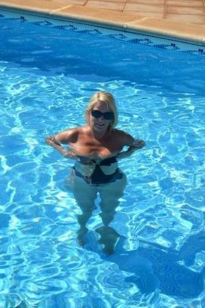 Middle-aged blonde Sweet Susi frees her tits & pussy from a swimsuit by a pool on chickinfo.com