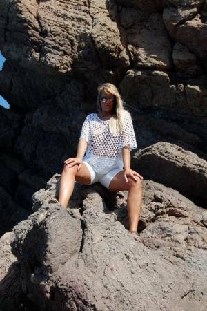 Blonde amateur Sweet Susi exposes her tits and ass on a rocks by the sea on chickinfo.com