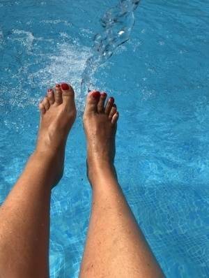 Mature woman Sweet Susi dips her painted toenails into a swimming pool on chickinfo.com