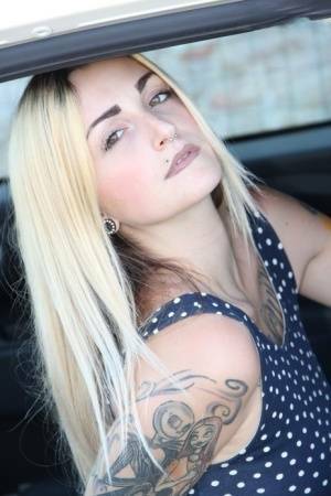 Tattooed girl Medusa Blonde shows her bare feet and ass while in a car on chickinfo.com