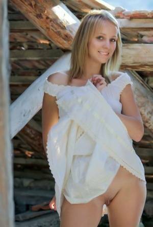 Young blonde Ilona D gets naked in a rustic setting with her boots on on chickinfo.com