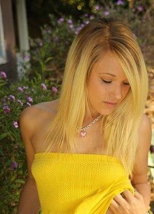 Blonde amateur Teagan bares her A-cup tits in a yard as she gets totally naked on chickinfo.com