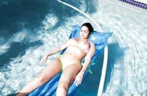 Brunette babe model Ada S going topless on air mattress in swimming pool on chickinfo.com