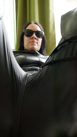 Dark haired amateur models a leather catsuit while wearing dark sunglasses on chickinfo.com
