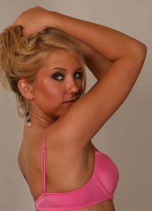 Blonde amateur Jocalynn piles up her hair before getting naked on a bed on chickinfo.com