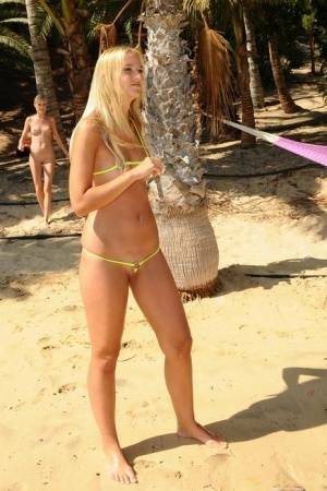 Natural blonde takes off her bikini to get totally naked on a beach on chickinfo.com